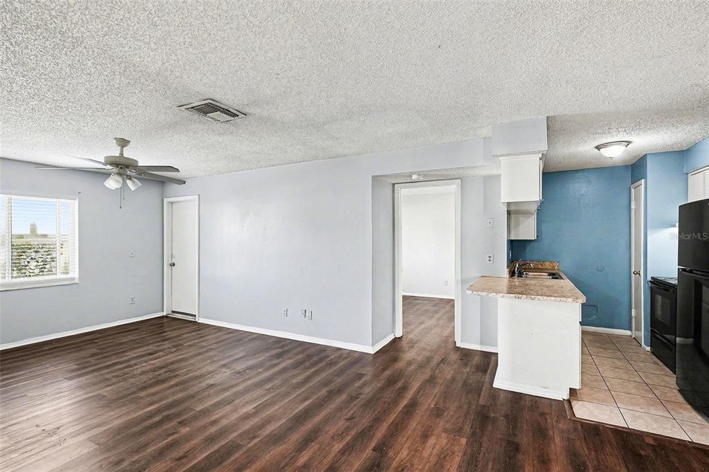 550 Golden Raintree Place, Unit 550 Brandon, FL 33510 - Photo 7 of 33 a kitchen with a wooden floor a stove and a refrigerator
