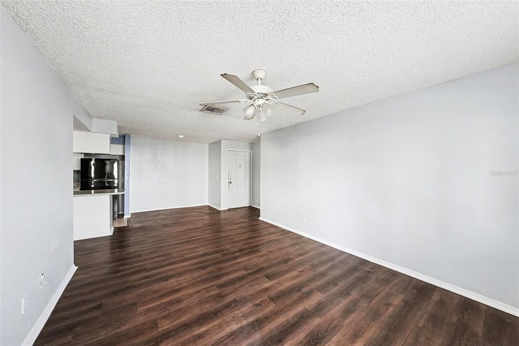 550 Golden Raintree Place, Unit 550 Brandon, FL 33510 - Photo 8 of 33 a view of an empty room with wooden floor and a ceiling fan