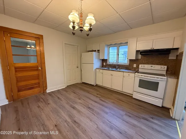 a kitchen with stainless steel appliances granite countertop a white cabinets a stove a sink and dishwasher