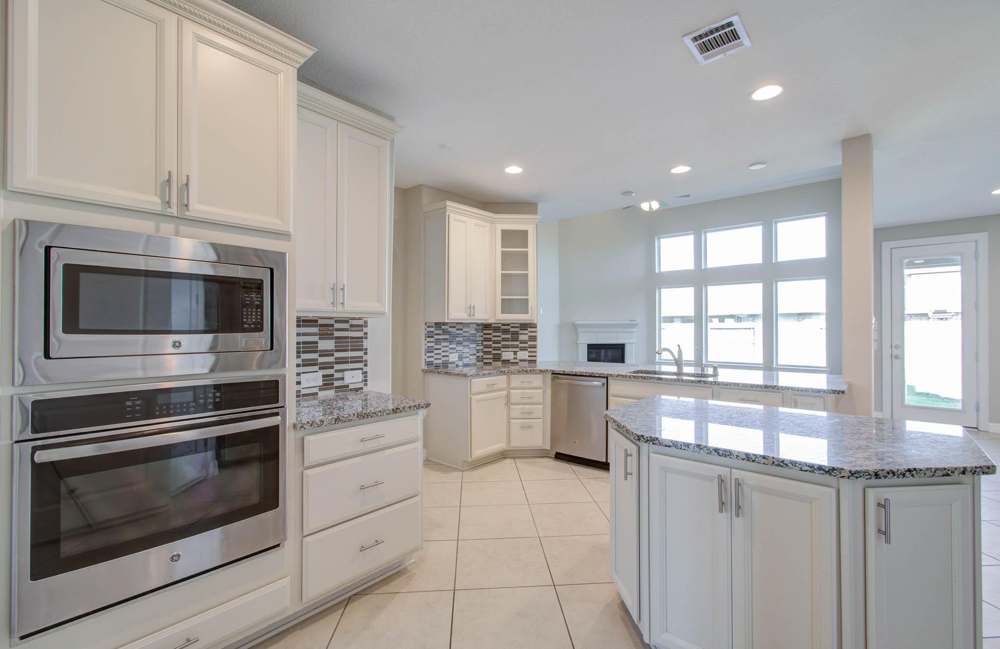 27911 Seger Bnd Trail Spring, TX 77386 - Photo 23 of 49 a kitchen with stainless steel appliances white cabinets and a stove