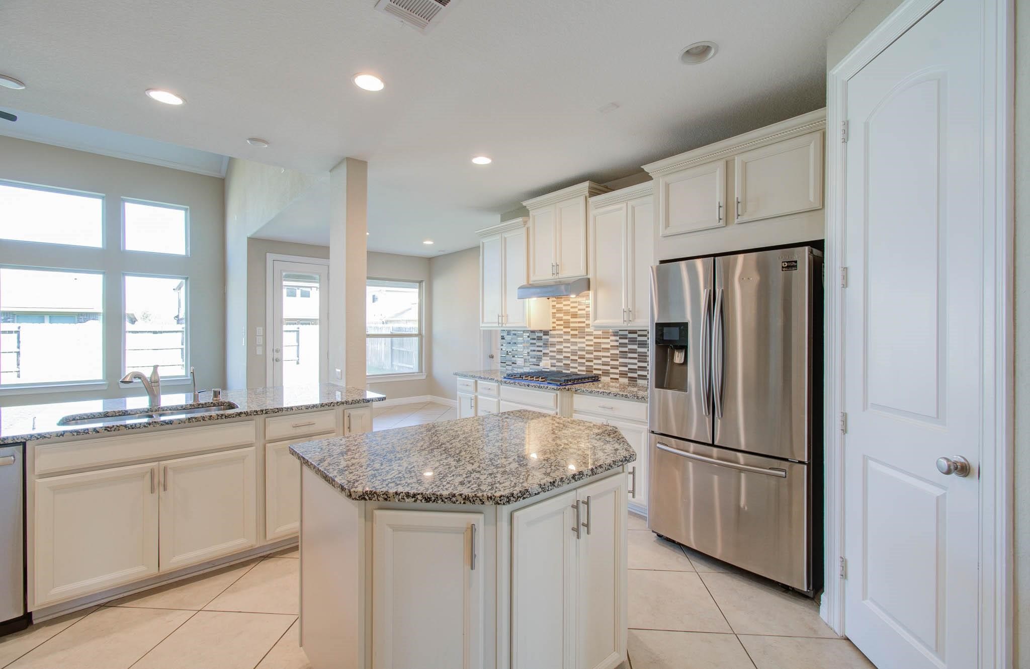 27911 Seger Bnd Trail Spring, TX 77386 - Photo 24 of 49 a kitchen with stainless steel appliances granite countertop a refrigerator a sink and white cabinets