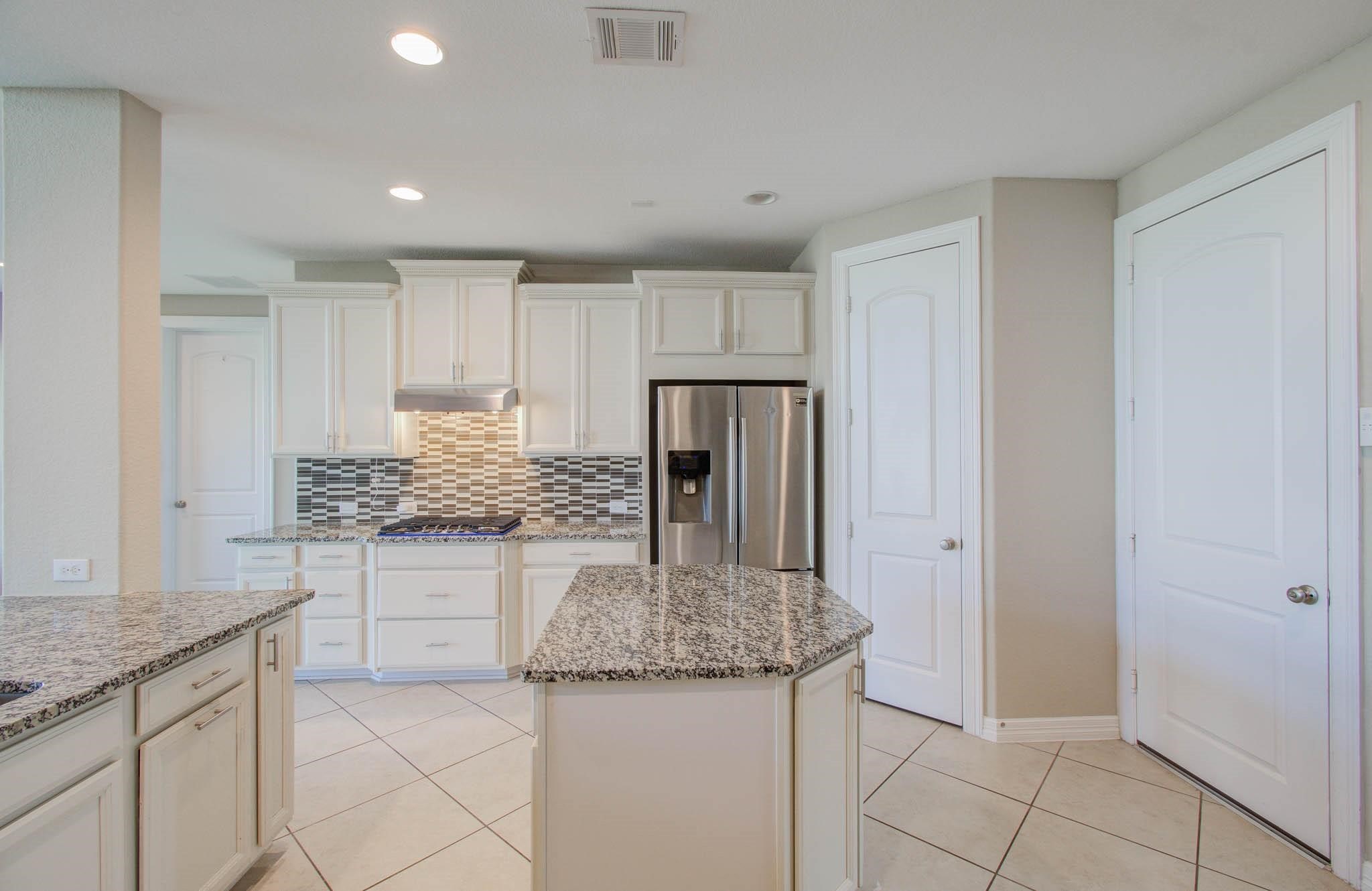 27911 Seger Bnd Trail Spring, TX 77386 - Photo 25 of 49 a kitchen with granite countertop a sink and a refrigerator