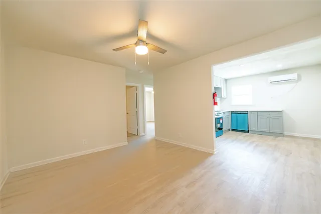 an empty room with wooden floor and ceiling fan