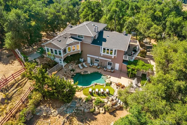 an aerial view of a house with a garden and lake view