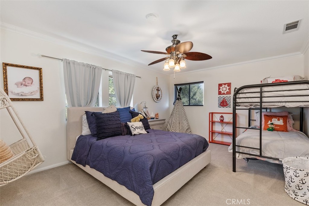 35455 El Niguel Road Lake Elsinore, CA 92530 - Photo 41 of 58 a spacious bedroom with a bed and a chandelier