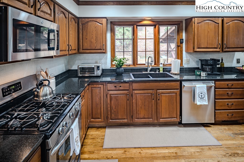 281 Old Hartley Road Banner Elk, NC 28604 - Photo 14 of 50 a kitchen with granite countertop a stove top oven cabinetry a sink and a window