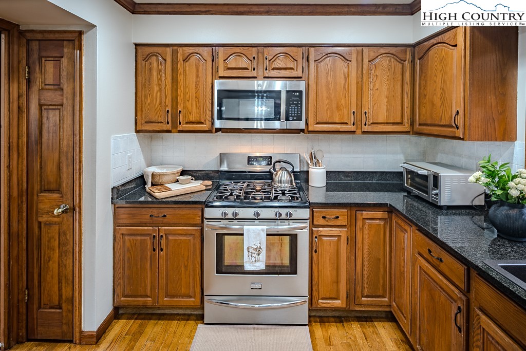 281 Old Hartley Road Banner Elk, NC 28604 - Photo 15 of 50 a kitchen with stainless steel appliances granite countertop a stove a sink and a microwave
