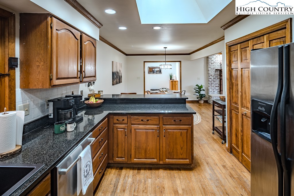 281 Old Hartley Road Banner Elk, NC 28604 - Photo 16 of 50 a kitchen with stainless steel appliances granite countertop a refrigerator a sink dishwasher a stove and white countertops with wooden floor