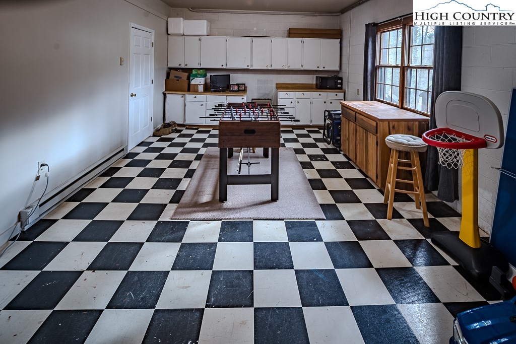 281 Old Hartley Road Banner Elk, NC 28604 - Photo 38 of 50 a kitchen with a checkered floor and white cabinets