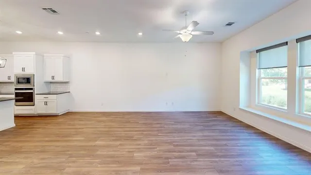 a view of kitchen with wooden floor and electronic appliances