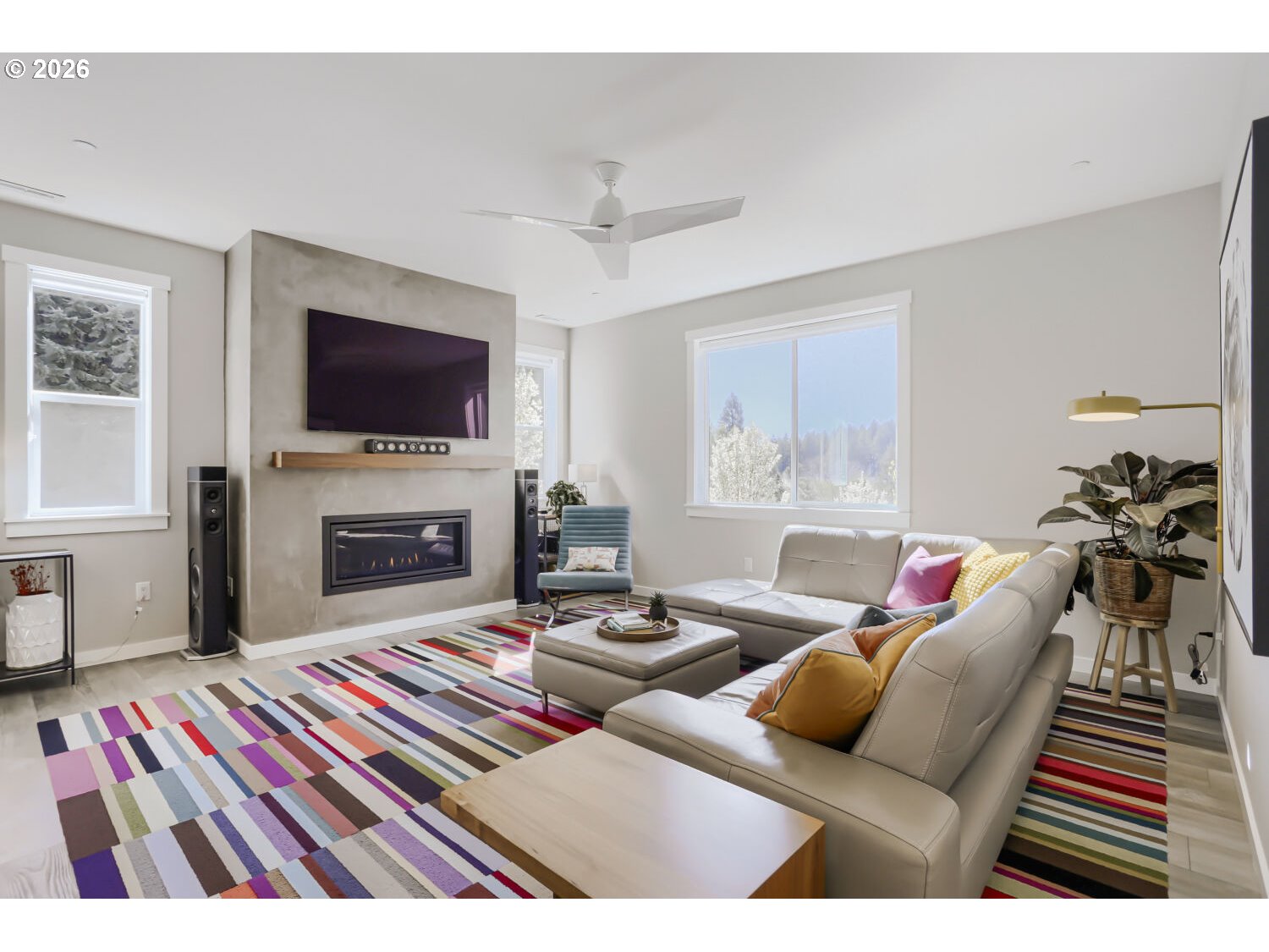 9957 Southwest 173rd Avenue Beaverton, OR 97007 - Photo 12 of 45 a living room with furniture a flat screen tv and a fireplace