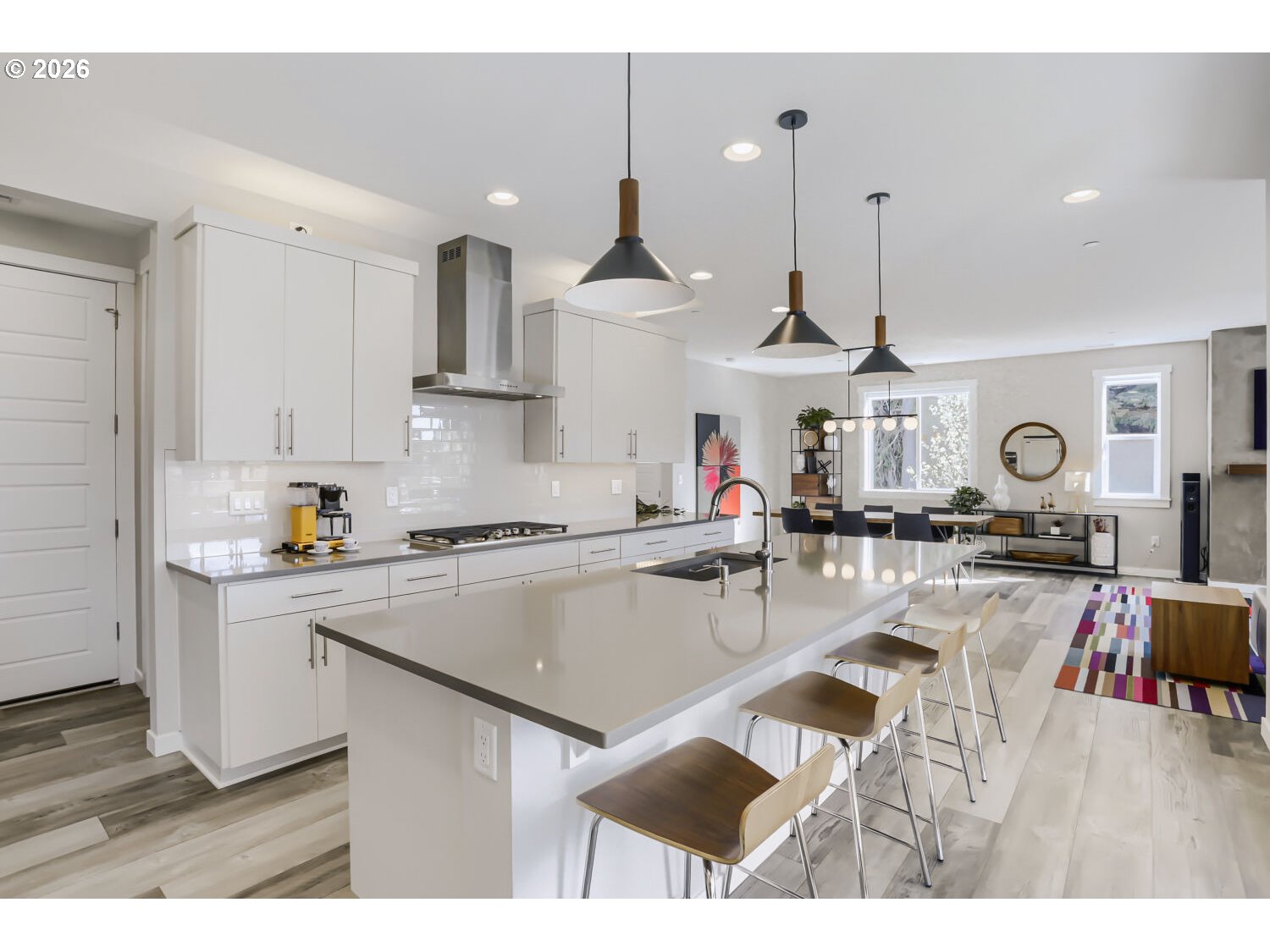 9957 Southwest 173rd Avenue Beaverton, OR 97007 - Photo 15 of 45 a kitchen with stainless steel appliances granite countertop a sink dishwasher a stove and white cabinets with wooden floor