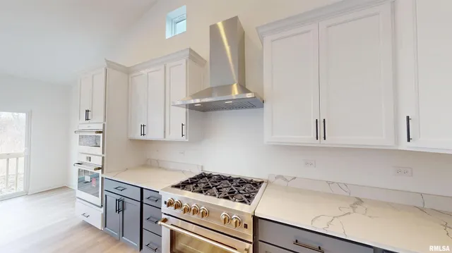 a kitchen with stainless steel appliances a stove and white cabinets