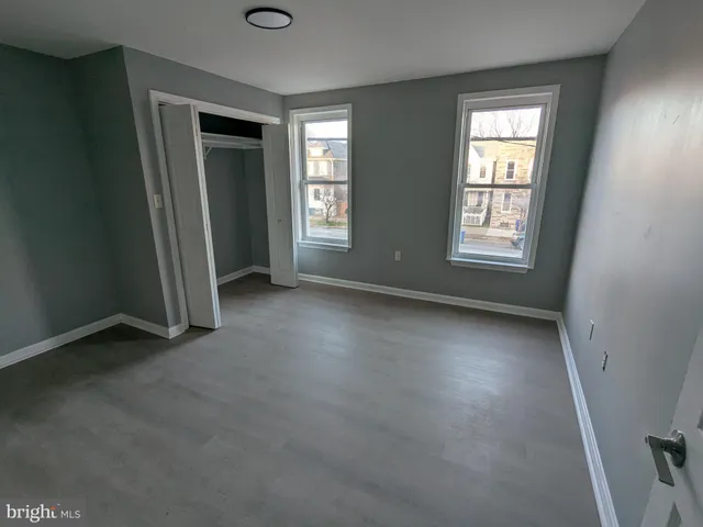 an empty room with windows and closet