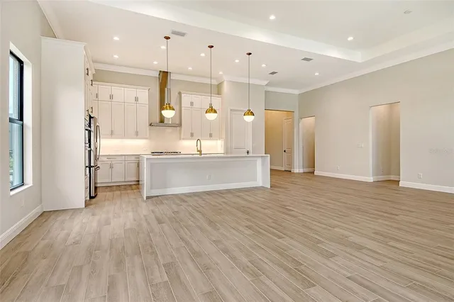 a large room with a lot of kitchen stainless steel appliances and wooden floor