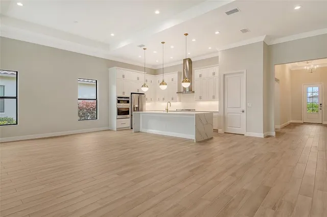 a view of a kitchen with a sink dishwasher stove and cabinets