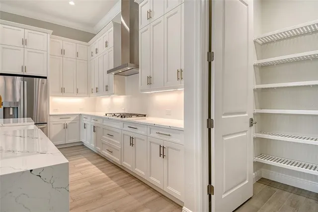 a white kitchen with granite countertop white cabinets and stainless steel appliances