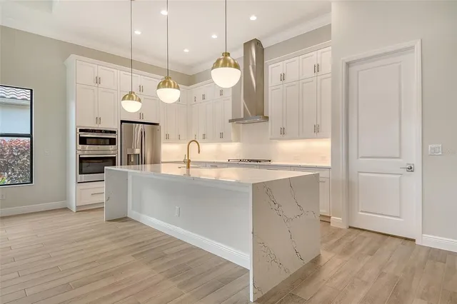 a large kitchen with a lot of counter space and wooden floor