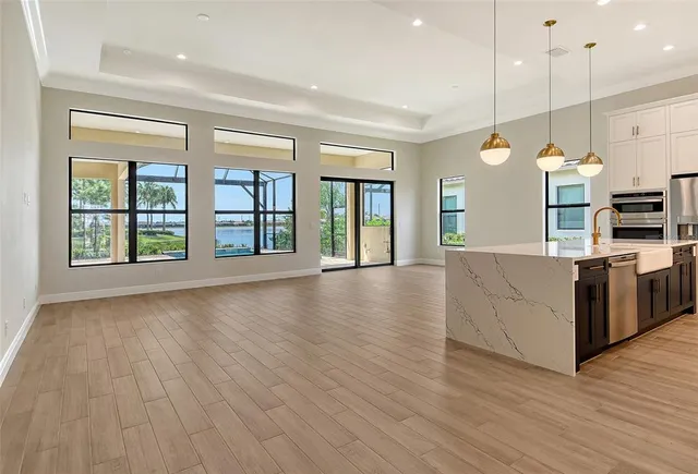 a large kitchen with stainless steel appliances granite countertop a stove and a wooden floors