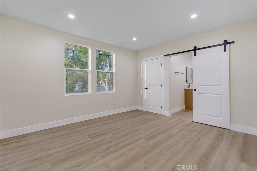700 West 10th Street Azusa, CA 91702 - Photo 15 of 43 a view of an empty room with a window and wooden floor