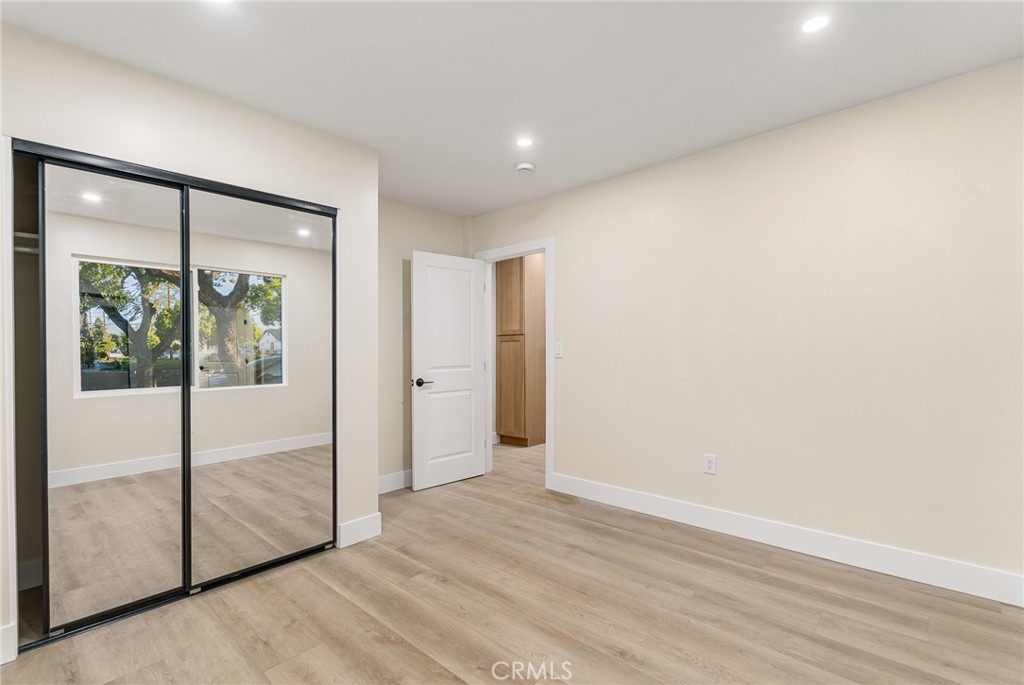 700 West 10th Street Azusa, CA 91702 - Photo 22 of 43 an empty room with wooden floor and door