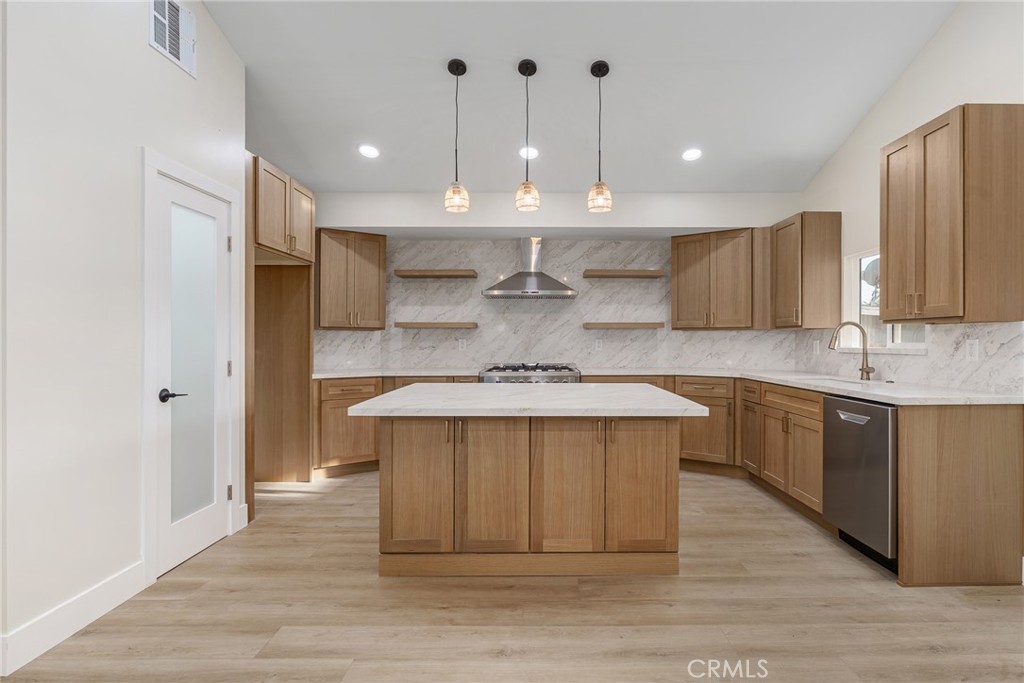 700 West 10th Street Azusa, CA 91702 - Photo 8 of 43 a kitchen with kitchen island a sink stainless steel appliances and cabinets