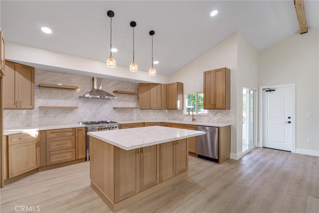 700 West 10th Street Azusa, CA 91702 - Photo 9 of 43 a kitchen with stainless steel appliances granite countertop a sink a stove a refrigerator and island with wooden floor