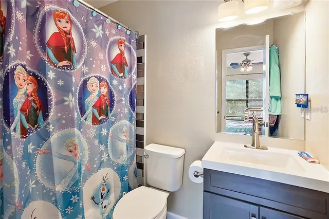 a bathroom with a sink and mirror with toilet