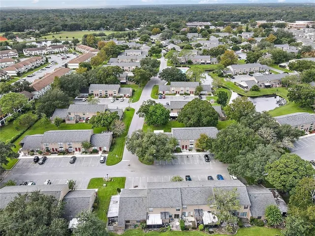 an aerial view of residential houses with outdoor space and parking