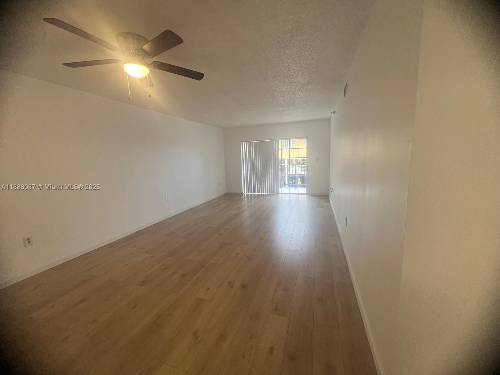 8900 Collins Avenue, Unit 203 Surfside, FL 33154 - Photo 3 of 11 an empty room with wooden floor and windows