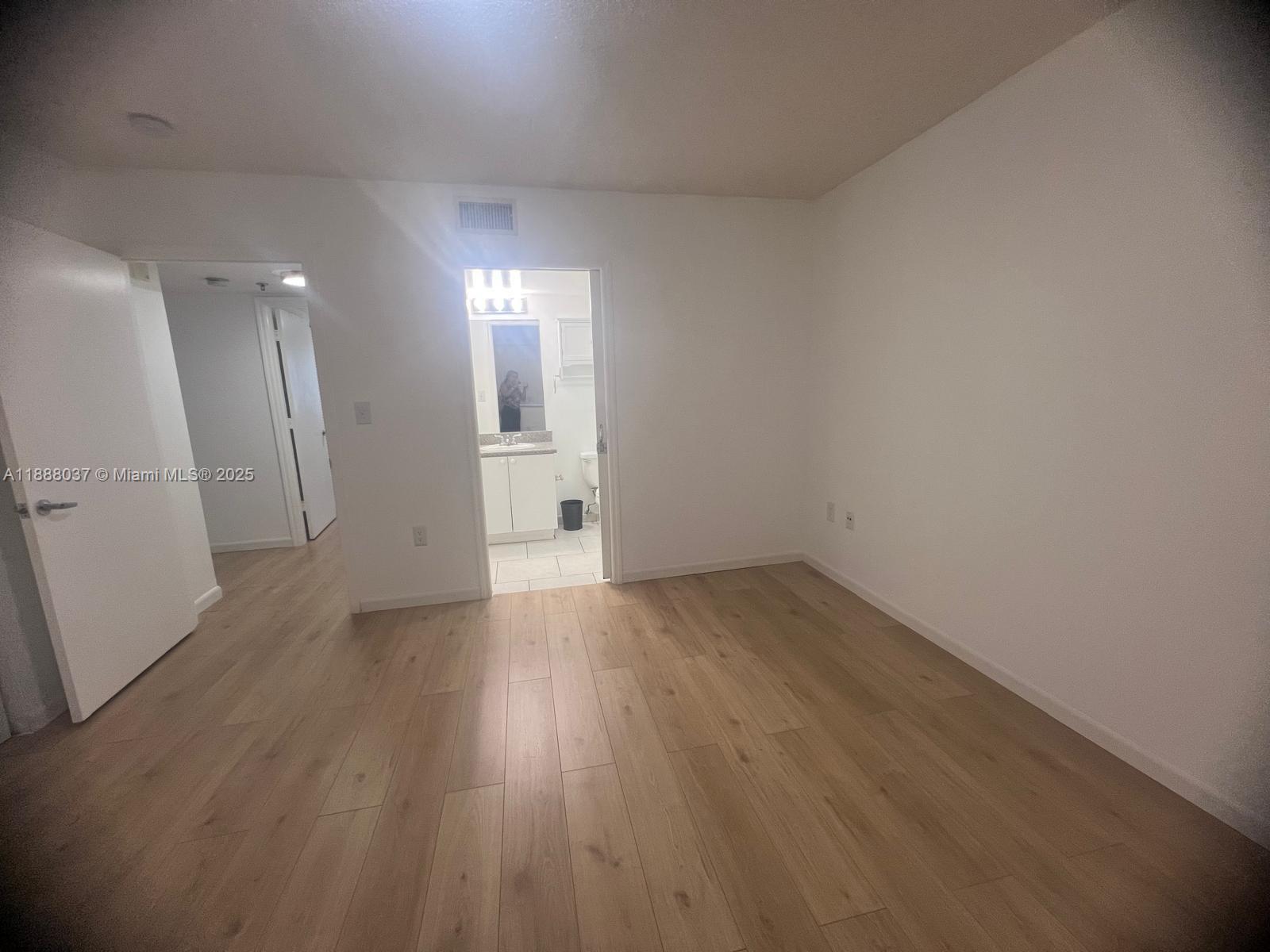 8900 Collins Avenue, Unit 203 Surfside, FL 33154 - Photo 6 of 11 a view of an empty room and wooden floor
