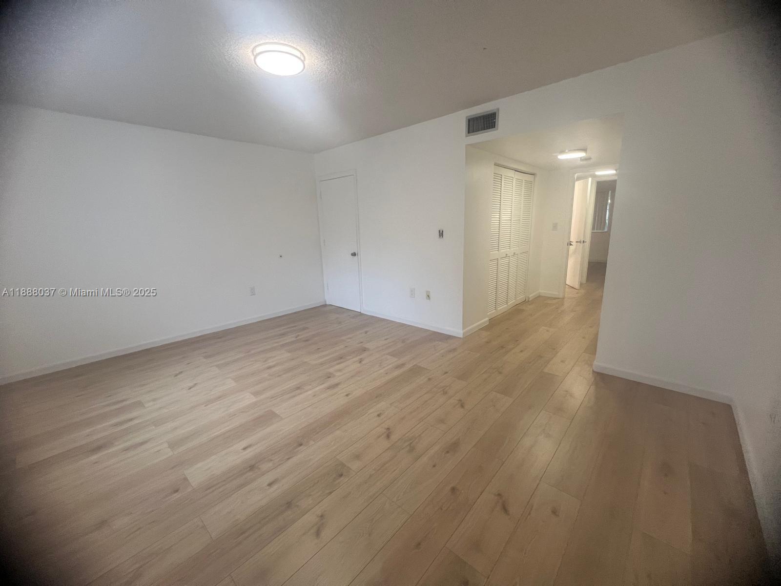 8900 Collins Avenue, Unit 203 Surfside, FL 33154 - Photo 9 of 11 an empty room with wooden floor and windows