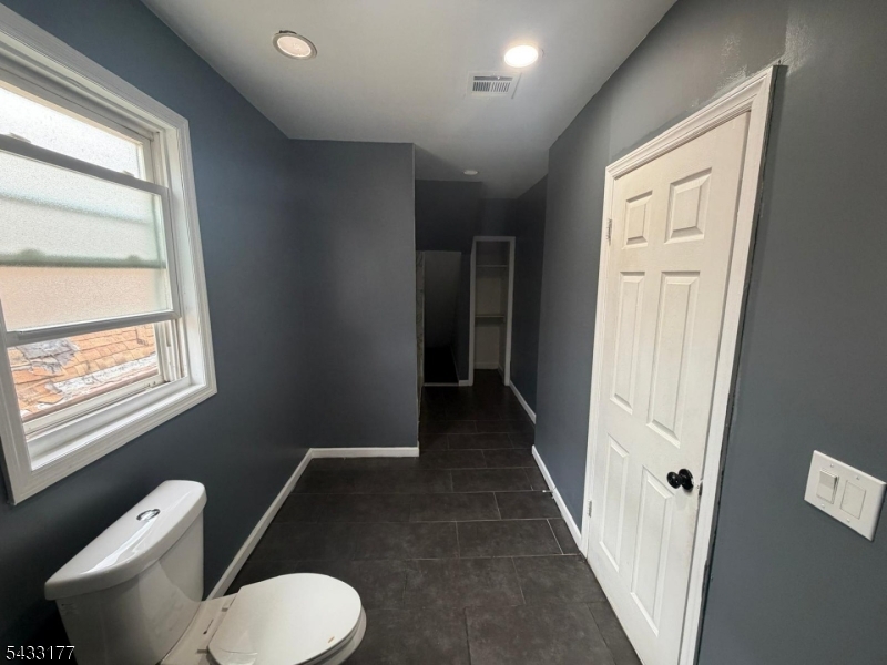 166 Renner Avenue, Unit 3 Newark, NJ 07112 - Photo 12 of 24 a bathroom with a toilet tub sink and mirror