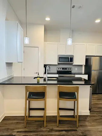 a kitchen with stainless steel appliances granite countertop a stove a sink and a refrigerator
