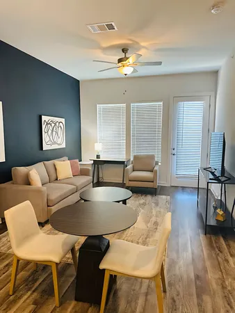a living room with furniture and wooden floor