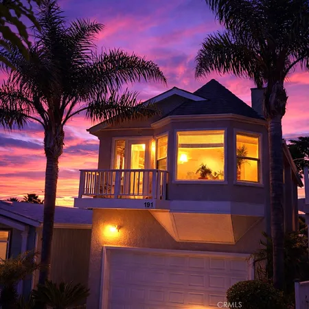 a front view of a house with fountain bath tub and palm trees