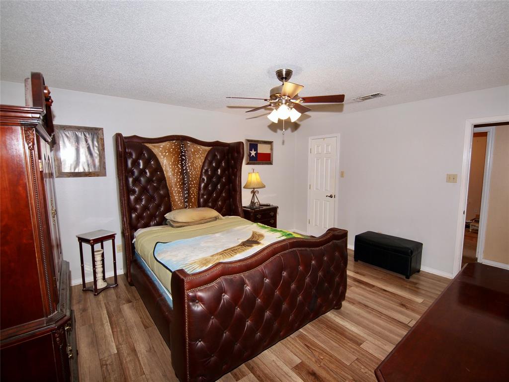 3106 South Lipsey Street Decatur, TX 76234 - Photo 11 of 27 a bed room with a bed and a chandelier