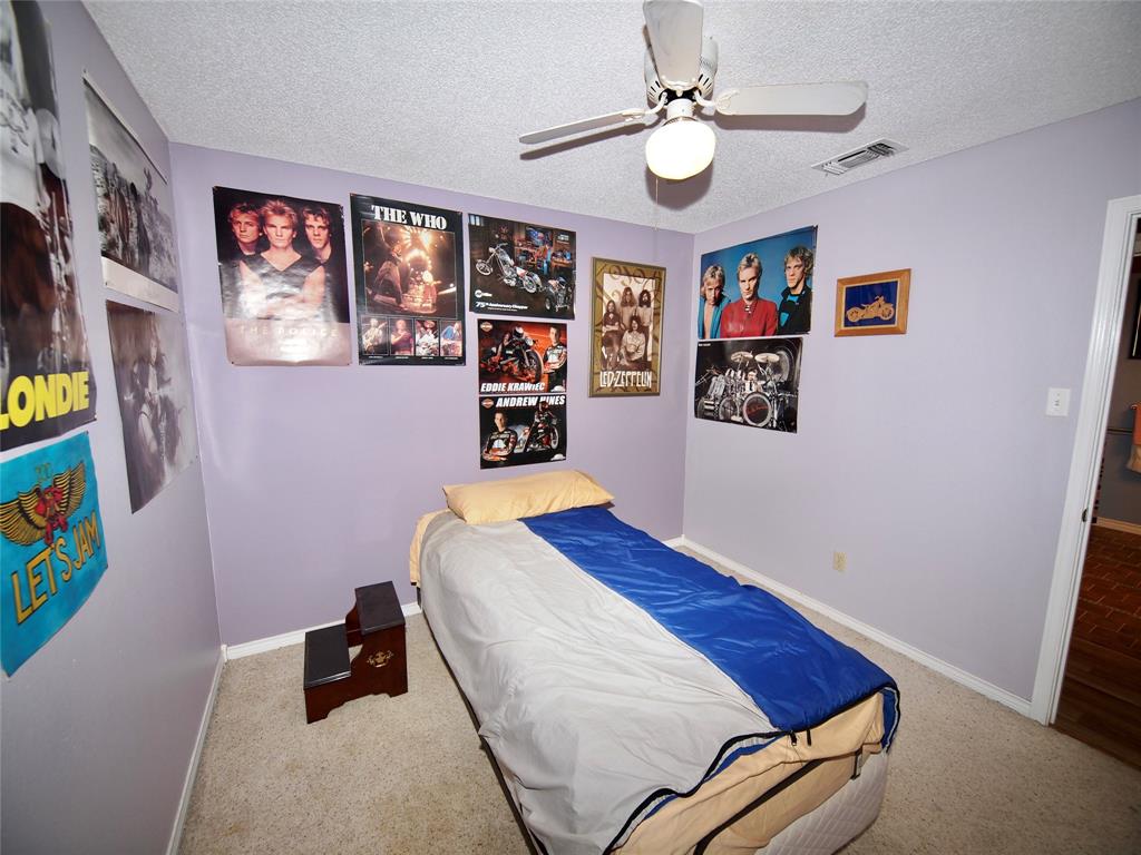 3106 South Lipsey Street Decatur, TX 76234 - Photo 14 of 27 a bedroom with a bed and a chandelier