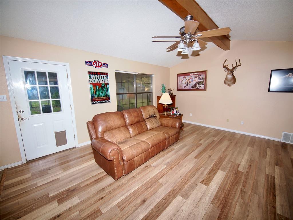 3106 South Lipsey Street Decatur, TX 76234 - Photo 4 of 27 a living room with couches and a dining table with wooden floor