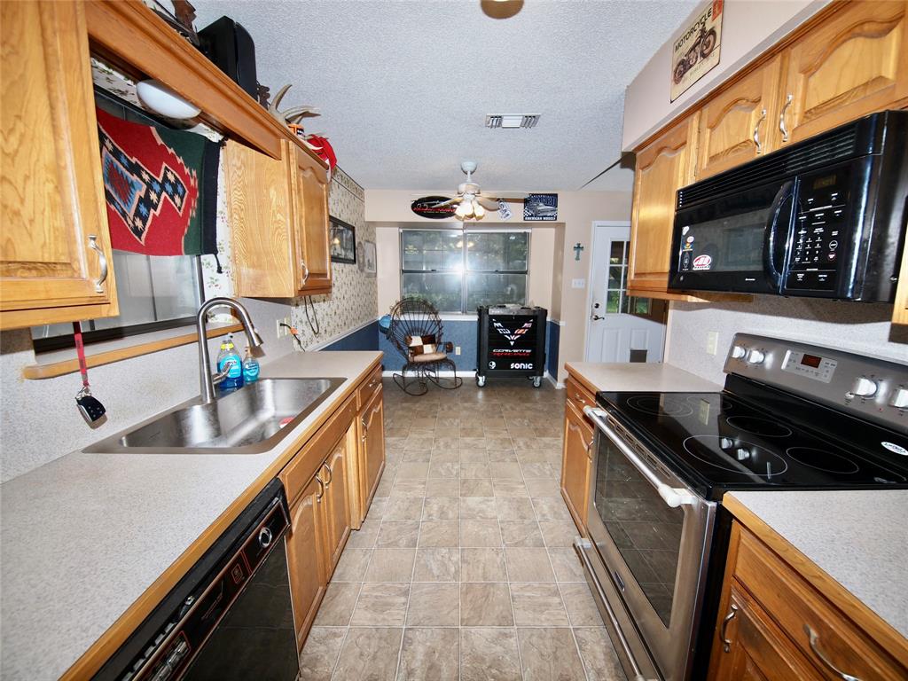 3106 South Lipsey Street Decatur, TX 76234 - Photo 8 of 27 a kitchen with stainless steel appliances a sink stove and cabinets