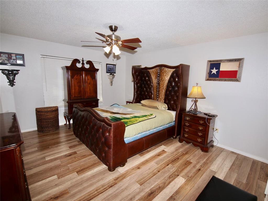 3106 South Lipsey Street Decatur, TX 76234 - Photo 10 of 27 a bedroom with a bed and wooden floor