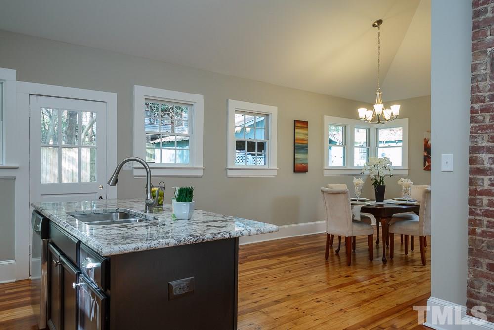 605 North East Street Raleigh, NC 27604 - Photo 8 of 25 a kitchen with granite countertop a stove a dining table and chairs