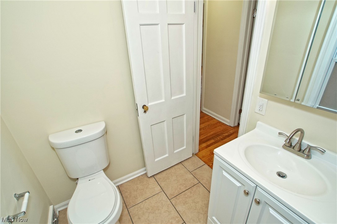 1387 Winston Road Cleveland, OH 44121 - Photo 21 of 29 Bathroom featuring tile floors, toilet, and vanity with extensive cabinet space