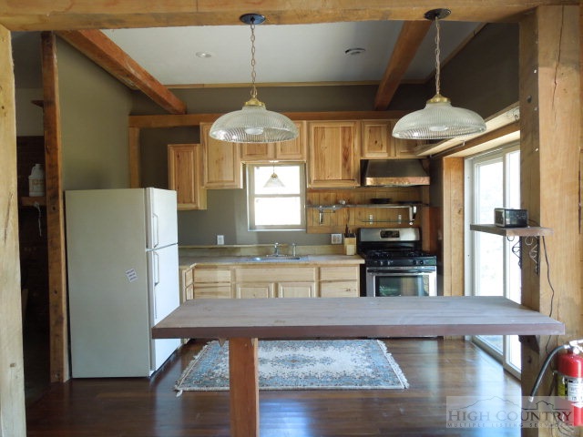 3086 Summit Road Purlear, NC 28665 - Photo 6 of 13 a kitchen with stainless steel appliances granite countertop a refrigerator a microwave oven a stove and a dining table with wooden floor