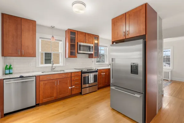 a kitchen with stainless steel appliances granite countertop a refrigerator a stove and a sink