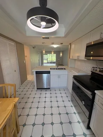 a kitchen with stainless steel appliances a stove a sink and a refrigerator