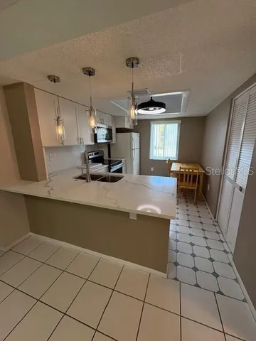 a kitchen with stainless steel appliances a stove a sink a counter top space and cabinets