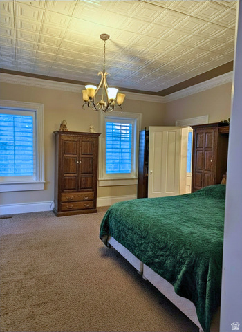 190 North 200 E Street Beaver, UT 84713 - Photo 27 of 40 Master bedroom featuring textured ceiling panels, a decorative chandelier, and crown molding