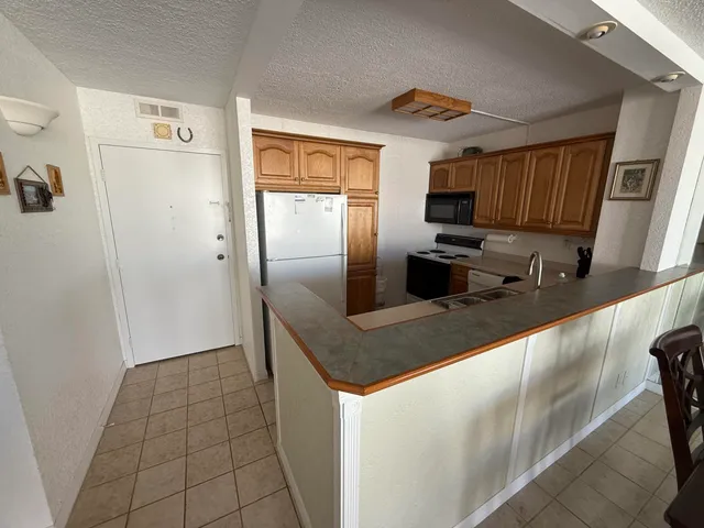 a kitchen with stainless steel appliances granite countertop a sink a refrigerator and a granite counter tops