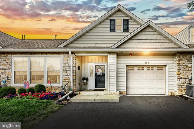 a view of a house with a yard and potted plants